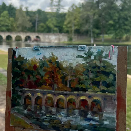 A serene landscape painting featuring a stone bridge over a body of water with trees on either side, under a partly cloudy sky.