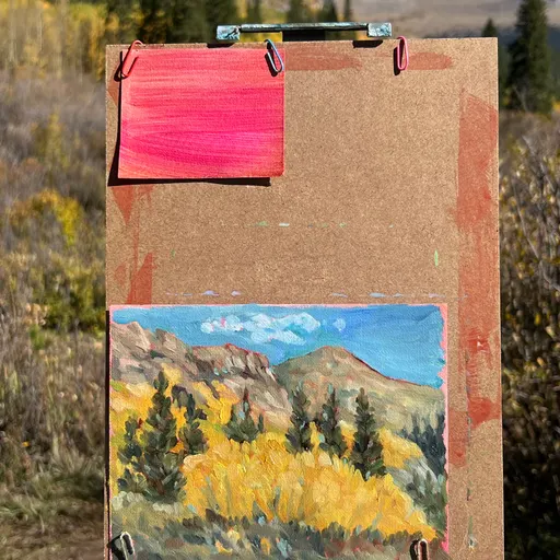 A small acrylic painting depicting a mountain landscape with autumn-colored trees in the foreground and a blue sky above.